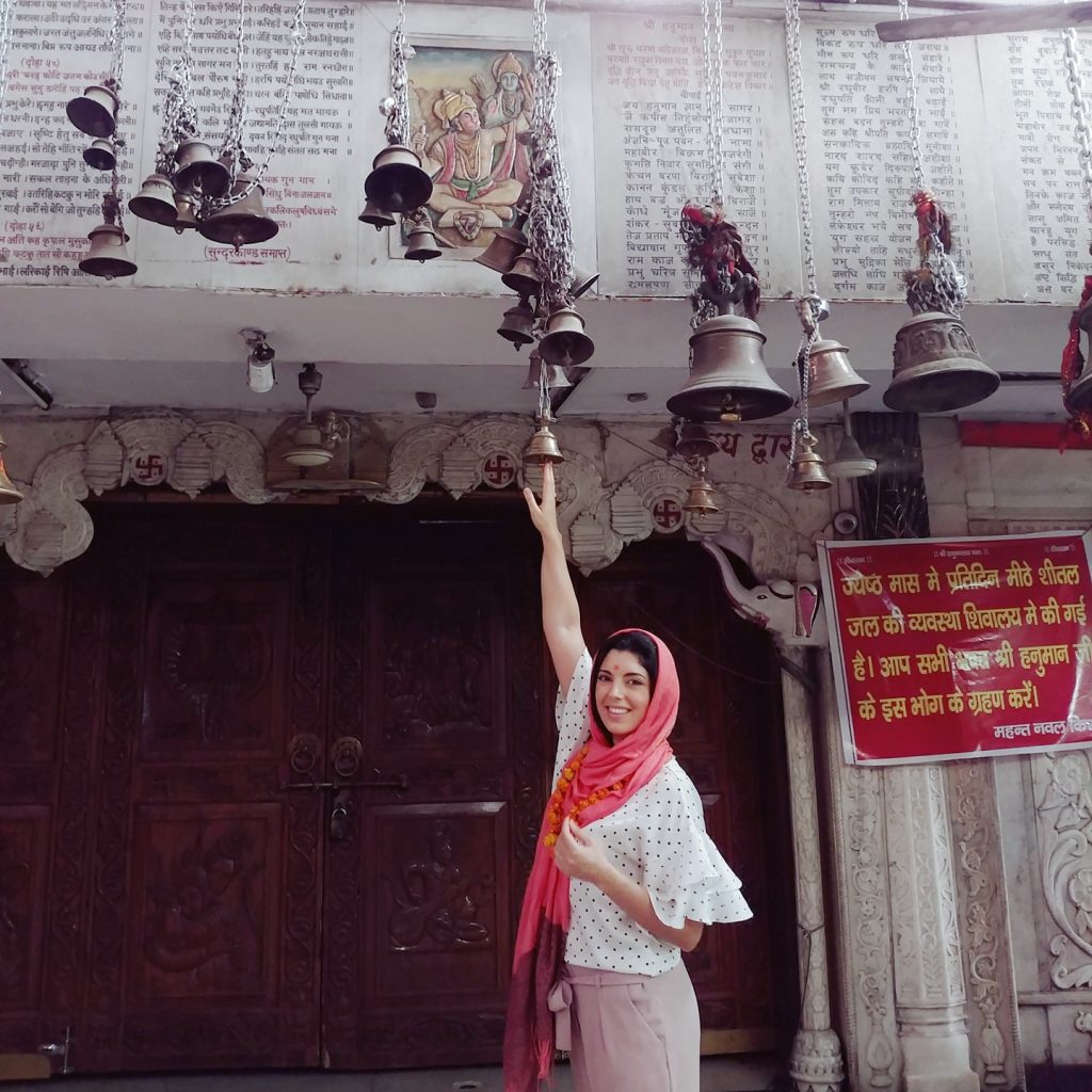 a girl is touchign the bells hanging from the ceiling for good fortune