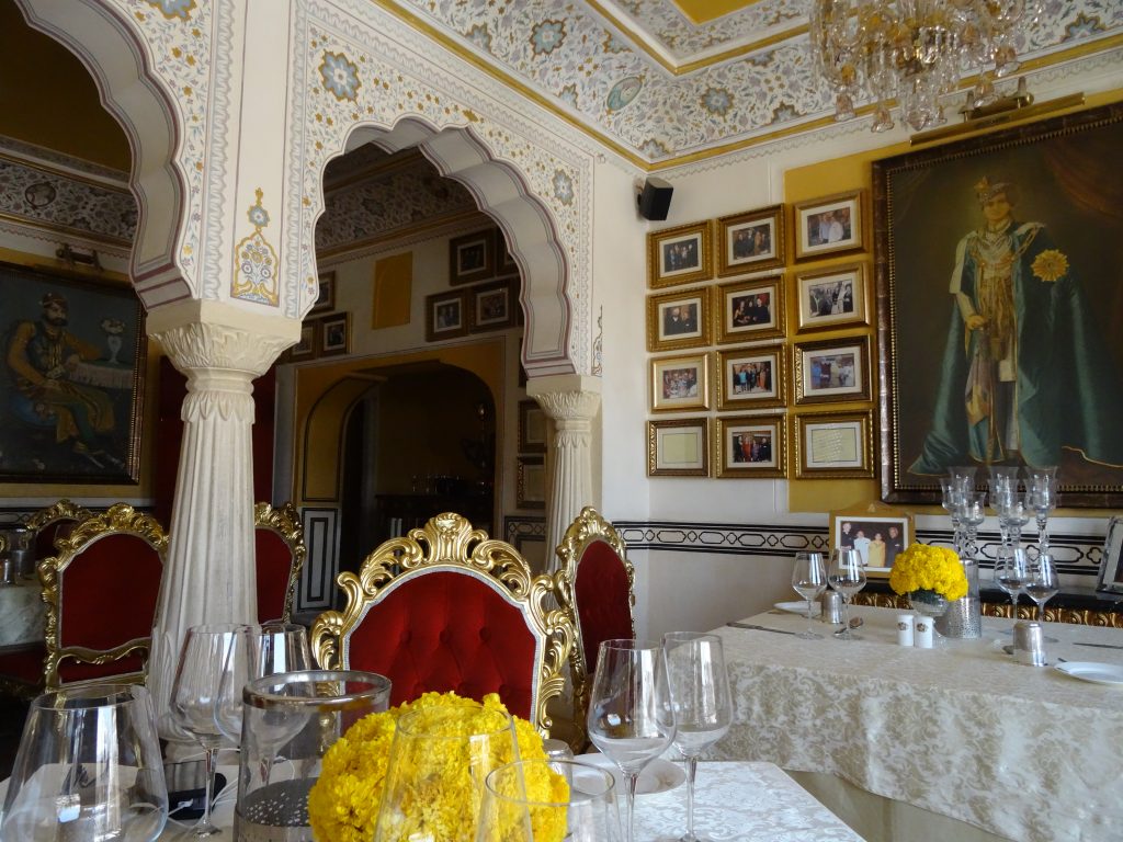decor inside the restaurant, a portrait of the king of Jaipur stands in front of the guests' tables