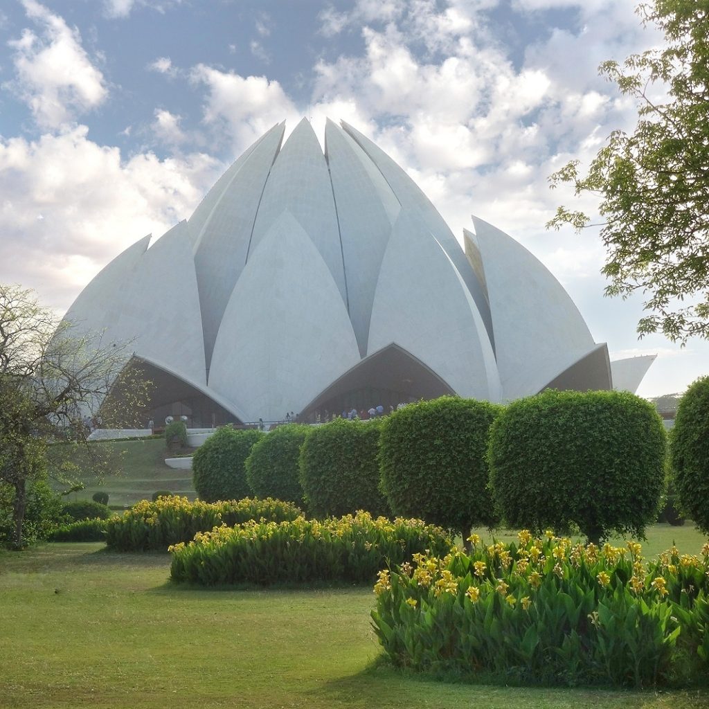 the flower shape building rises in the middle of beautiful gardens